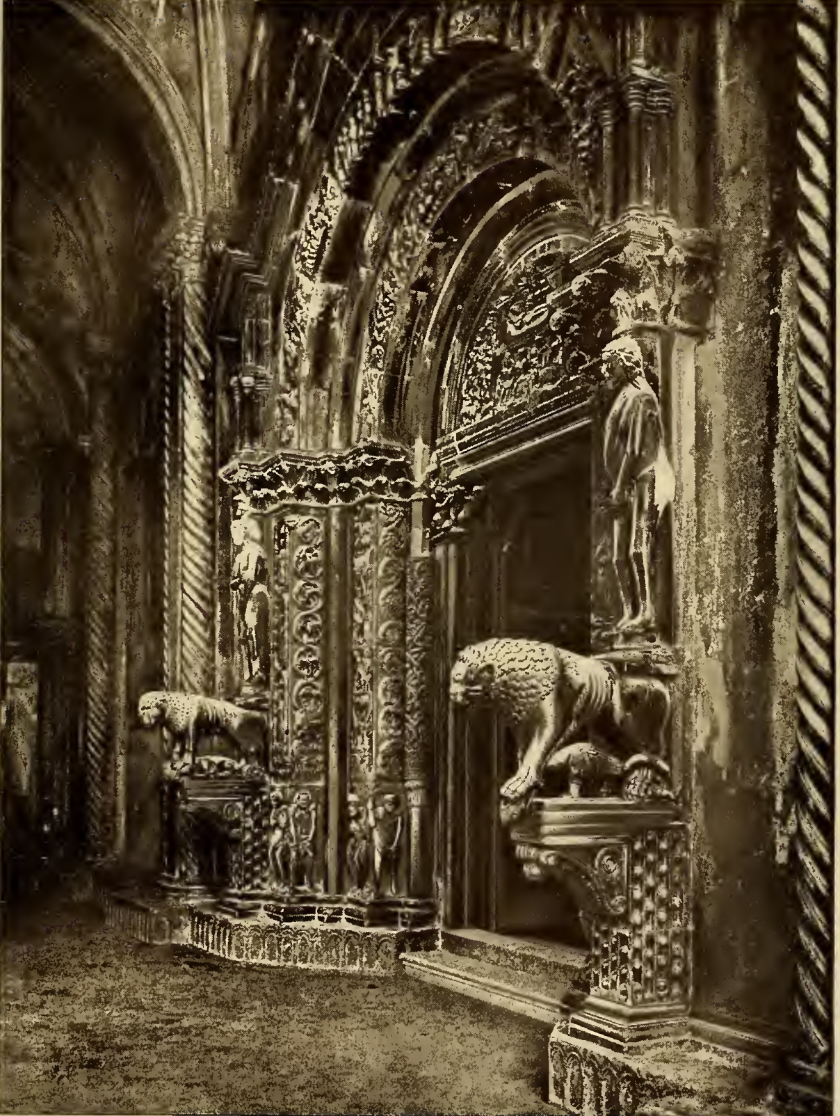 Ornate carved doorway, flanked by two lions. Caption: Traü Lion's Dooryway of the Cathedral.