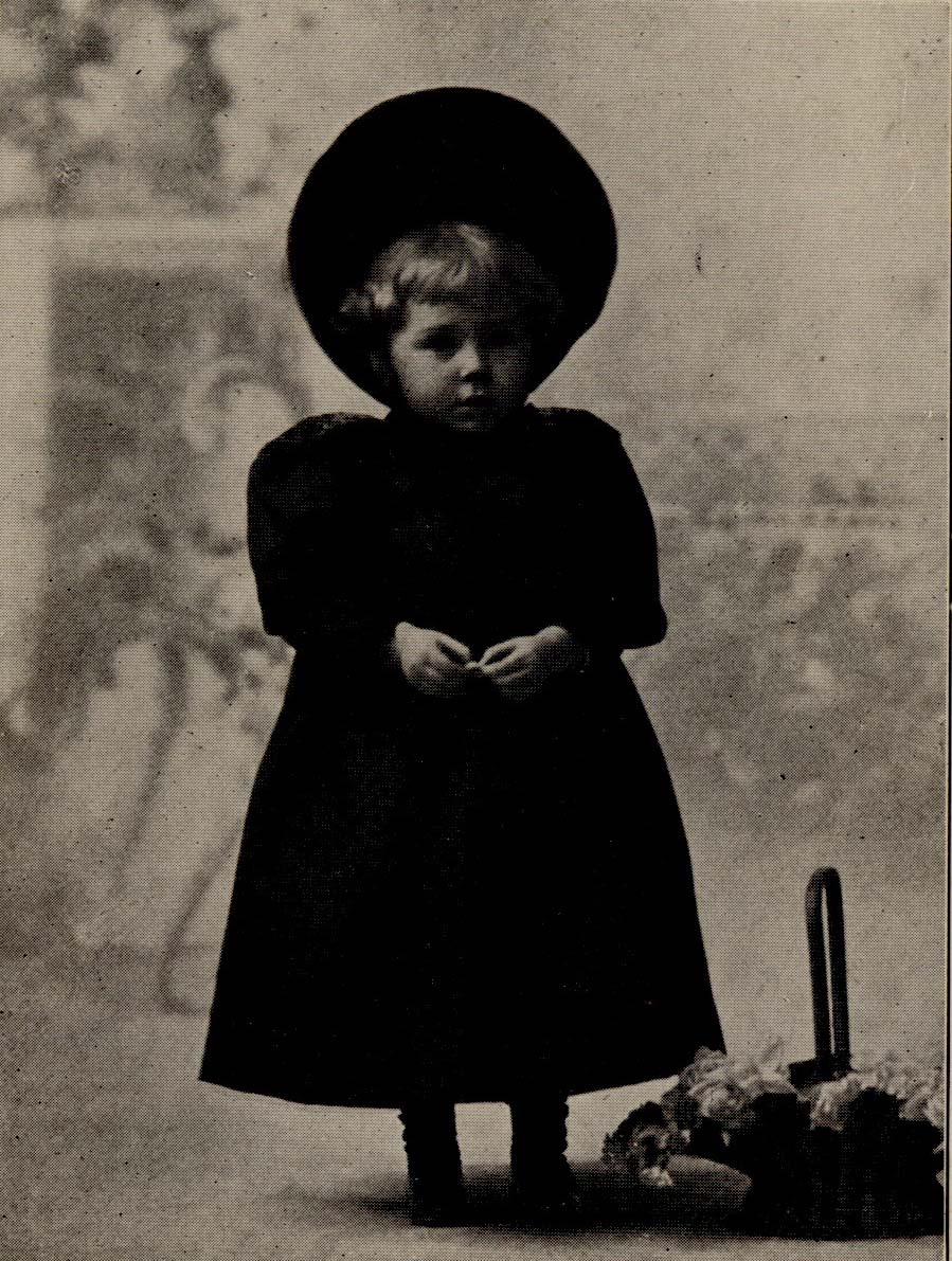 Marie standing in Victorian hat and dress.
