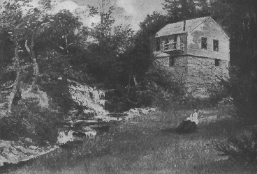 woman sitting in front of a house by a creek