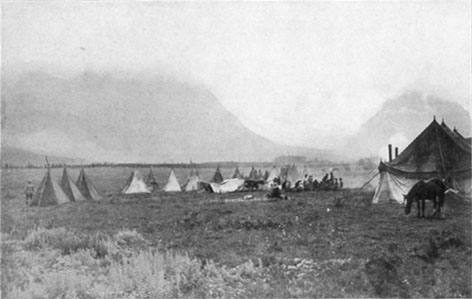  Tents and horses in an open field.