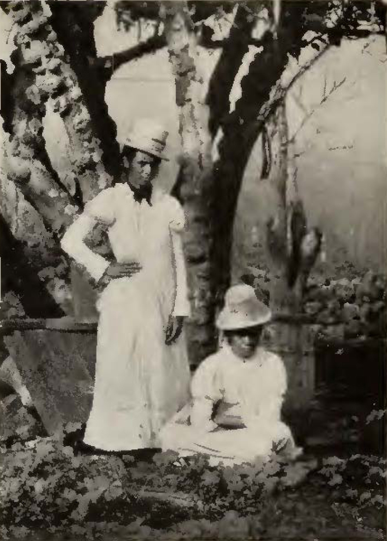 two women in white dresses and hats