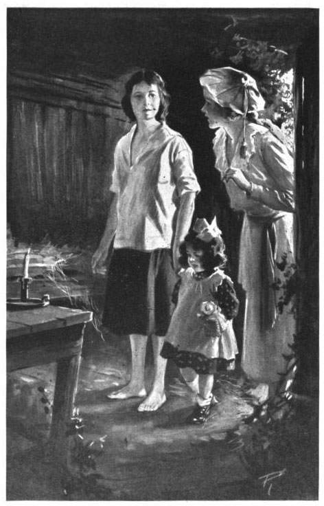A woman, a girl, and a little girl standing on a dirt floor. there is a small table with a candle before them.