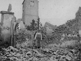 man standing atop rubble of a bombed-out house in what was previously the dining room
