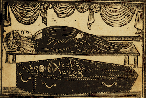 body of a man lying in state above a coffin