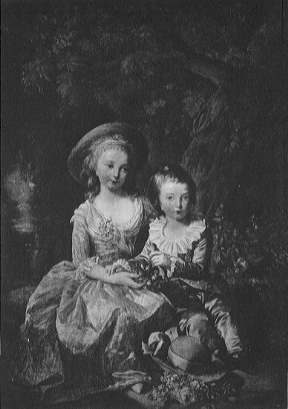 portrait of two children sitting under a tree with water in the background